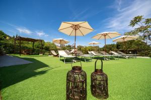 two metal containers sitting on the grass with umbrellas at Pater Meus Suites - Sea View, Pool & Parking in Cefalù