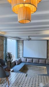 a room with a projection screen and a couch at HoneyPath Ocean Retreat in Tamraght Ouzdar