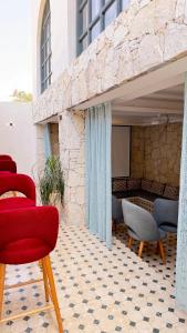 a patio with chairs and a screen on a building at HoneyPath Ocean Retreat in Tamraght Ouzdar