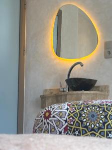 a bathroom with a sink and a mirror at HoneyPath Ocean Retreat in Tamraght Ouzdar