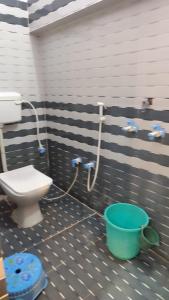 a bathroom with a toilet and a bucket at Ma jamwanti homestay in Ayodhya