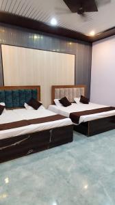 two beds are in a room with a wall at Ma jamwanti homestay in Ayodhya