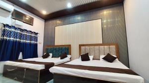two beds in a room with blue curtains at Ma jamwanti homestay in Ayodhya
