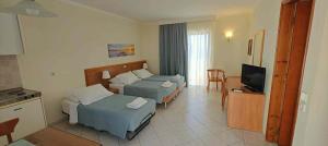 a hotel room with two beds and a television at Golden View Studios in Lindos +22 photos