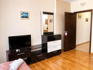 a living room with a flat screen tv and a dresser at Liora studio apartments in Sunny Beach +1 photo