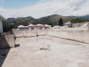 an outdoor area with a wall and mountains in the background at Spacious 2 Bed Room Home Attached Baths, Lounge & Kitchen in Abbottabad