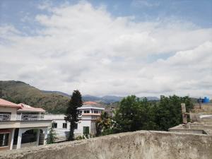 a view of a city with buildings and mountains at Spacious 2 Bed Room Home Attached Baths, Lounge & Kitchen in Abbottabad