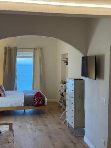 a bedroom with a bed and a dresser with a television at B&B Tre Finestre sul Mare in Grottammare