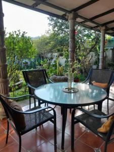 a table and chairs on a porch with a view at GuacamayaGuestHouse in Concepción de Ataco