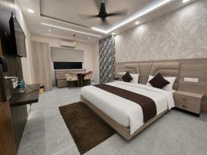 a bedroom with a large bed and a living room at Aaditri Inn in Gorakhpur