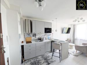a white kitchen with a sink and a counter at P6 Lipowa in Pisz