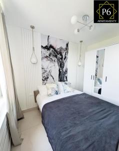 a bedroom with a bed with a painting on the wall at P6 Lipowa in Pisz