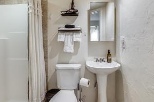 a white bathroom with a toilet and a sink at Work, Play & Explore w/ Ease! Dtwn Meridian Apt in Meridian +17 photos