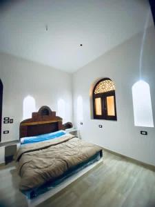 a white bedroom with a bed and a window at Rahma House Hostel in Tunis