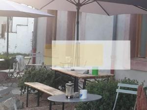 a table and two chairs and an umbrella at Nuit pour 2 en Auvergne in Vallon-en-Sully