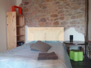 a bed in a bedroom with a stone wall at Nuit pour 2 en Auvergne in Vallon-en-Sully +3 photos
