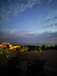 a balcony with chairs and a view of the city at Rahma House Hostel in Tunis
