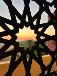 a view of the sunset through a metal fence at Rahma House Hostel in Tunis +5 photos