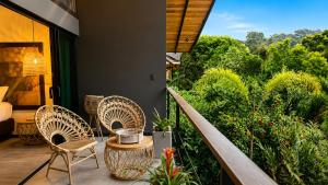 a balcony with two chairs and a table with a view at Namu Garden Hotel & Spa - Adults Only in Puerto Viejo