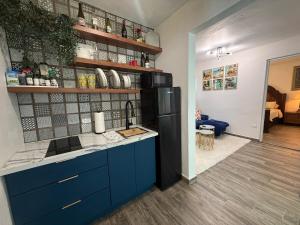 a kitchen with blue cabinets and a black refrigerator at Monterosso By Cinque Terre in Isabela