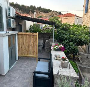 a small patio with a table and a bench at Lemnos Nest in Kondiás +6 photos
