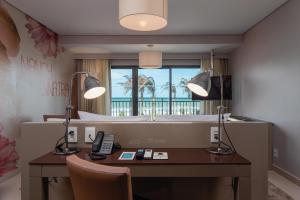 a room with a desk with two lamps and a mirror at Vila Galé Collection Sunset Cumbuco in Cumbuco