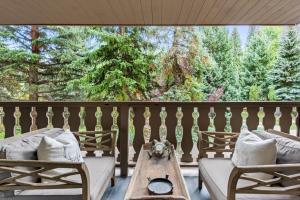 a porch with two beds and a table and chairs at Christiania Condominiums- CoralTree Residence Collection in Vail