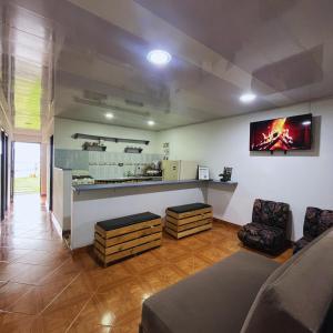 a living room with a bar and a tv on the wall at Casa la Colina in Macanal
