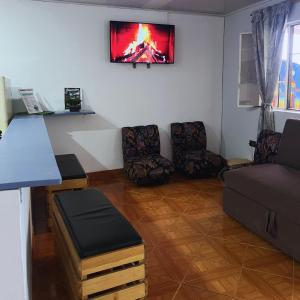 a living room with a couch and a tv on the wall at Casa la Colina in Macanal