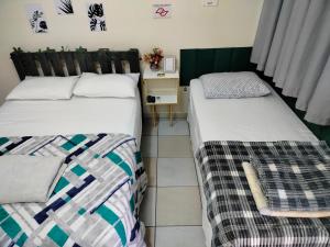two beds sitting next to each other in a room at Pernoitar in São José +10 photos