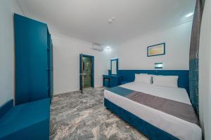 a bedroom with a blue and white bed and a door at Forest Garden in Goynuk