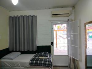 a bedroom with a bed and a window at Pernoitar in São José