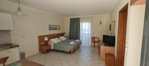 a hotel room with a bed and a television at Golden View Studios in Lindos