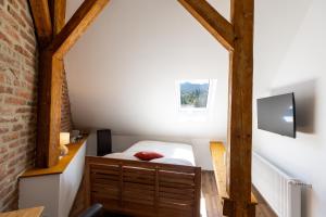 a small attic bedroom with a bed and a wall at Grünes Haus in Murau