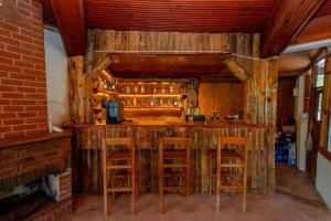 a bar in a room with wooden walls and stools at Forest Garden in Goynuk