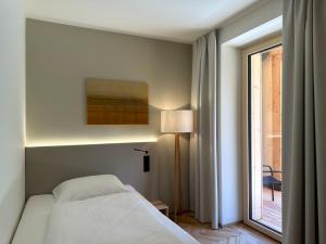 a bedroom with a white bed and a window at Haus der Achtsamkeit in Grünau im Almtal