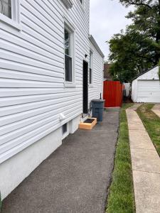 a white house with a window and a driveway at Cozy Private Two Bedroom Basement Apartment in Hempstead