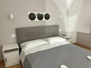 a bedroom with a bed with two tables and two plants at Largo Otranto - Guest House in Brindisi