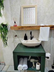 a bathroom with a sink on a green table at Pernoitar in São José