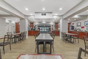 a dining room with tables and chairs and a kitchen at Best Western Plus Brunswick Bath in Brunswick