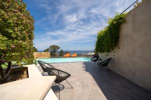 a patio with chairs and a swimming pool at Pater Meus Suites - Sea View, Pool & Parking in Cefalù +76 photos