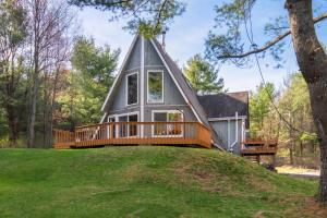 a tiny house on a hill with a deck at Camp Smores- Modern A-Frame with Pool in Newfield