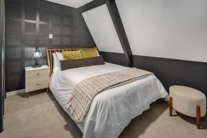 a bedroom with a bed and a chair at Camp Smores- Modern A-Frame with Pool in Newfield +46 photos