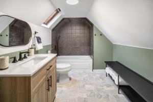 a bathroom with a sink and a toilet and a tub at Camp Smores- Modern A-Frame with Pool in Newfield