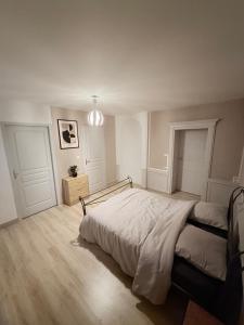 a white bedroom with a bed and a pendant light at Le pensionnat de Jeanne in Domrémy-la-Pucelle