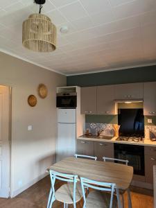 a kitchen with a table and two chairs and a counter at Le pensionnat de Jeanne in Domrémy-la-Pucelle
