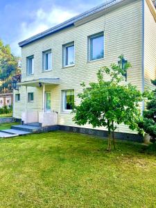 ein Haus mit einem Baum davor in der Unterkunft Hotel K.V.N. in Ragaciems
