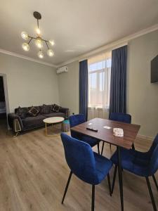 a living room with a table and blue chairs at Creative hotel in Gyumri