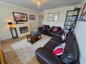 a living room with a leather couch and a table at Castle View Dover in Dover