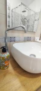 ein Badezimmer mit einem weißen Waschbecken und einem Spiegel in der Unterkunft Casa Eman in Barrea + 17 Fotos